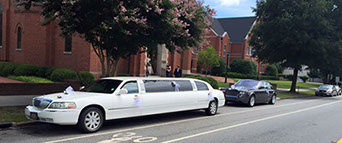 A stretch limousine waits outside the Catholic church in Greenville, SC, as a beautiful couple gets married on a gorgeous Saturday afternoon.
